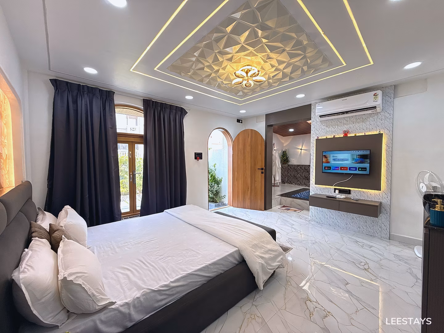 Bed with white linens and pillows in a room with marble floors and a decorative ceiling.