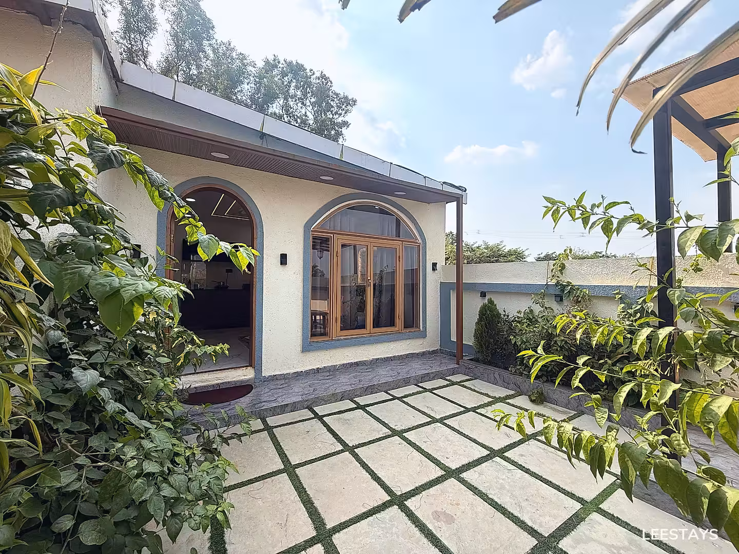 Exterior courtyard with stone tiles and green spaces.