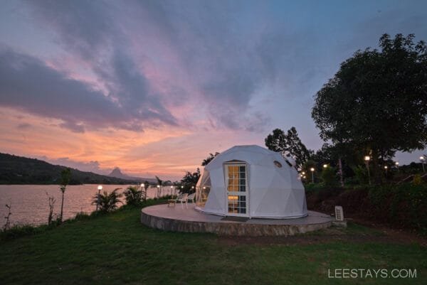 Geodesic dome structure at Dome Story Resort, Malvandi Lake, with a sunset sky in the background and the lake nearby.