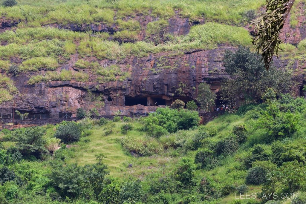 Lush green landscape with rocky hills near Lonavala, featuring caves, ideal for visitors looking for a picturesque resort getaway and nature exploration.