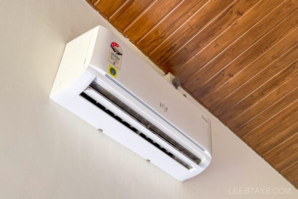 Air conditioning unit on a wooden ceiling in a cottage, typical of accommodations in Lonavala, offering comfort and cooling.